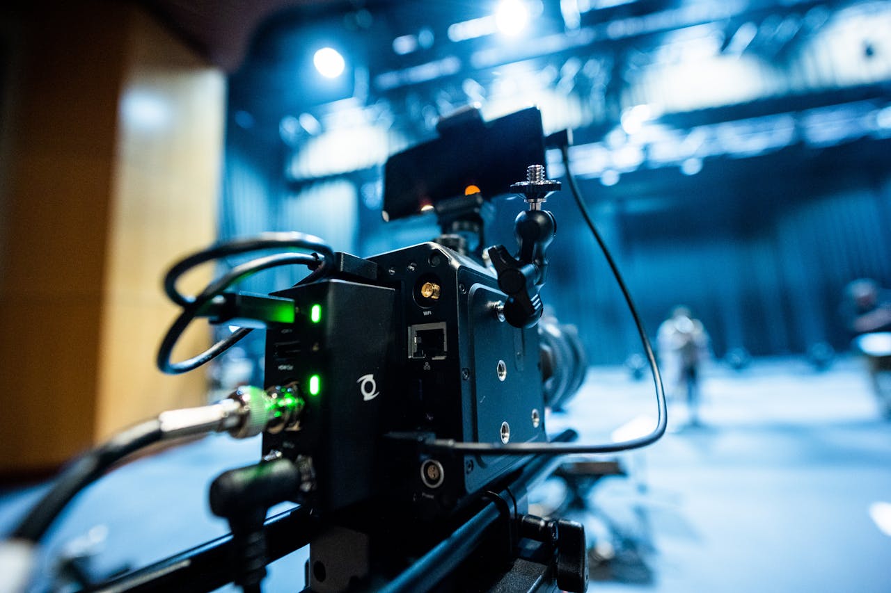 our-story Professional black video camera with wires located in professional recording studio during process of filming
